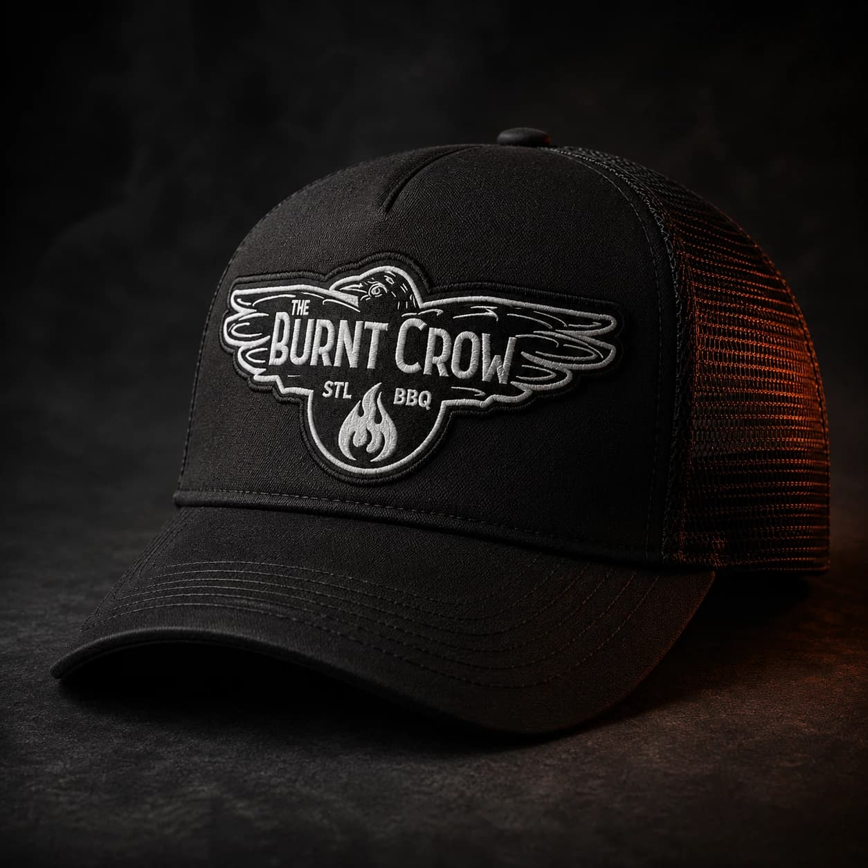 Black mesh-back trucker hat with an embroidered Burnt Crow logo patch