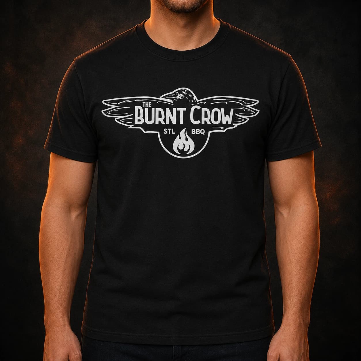 Adult model wearing the front of a black T-shirt with the white Burnt Crow classic logo